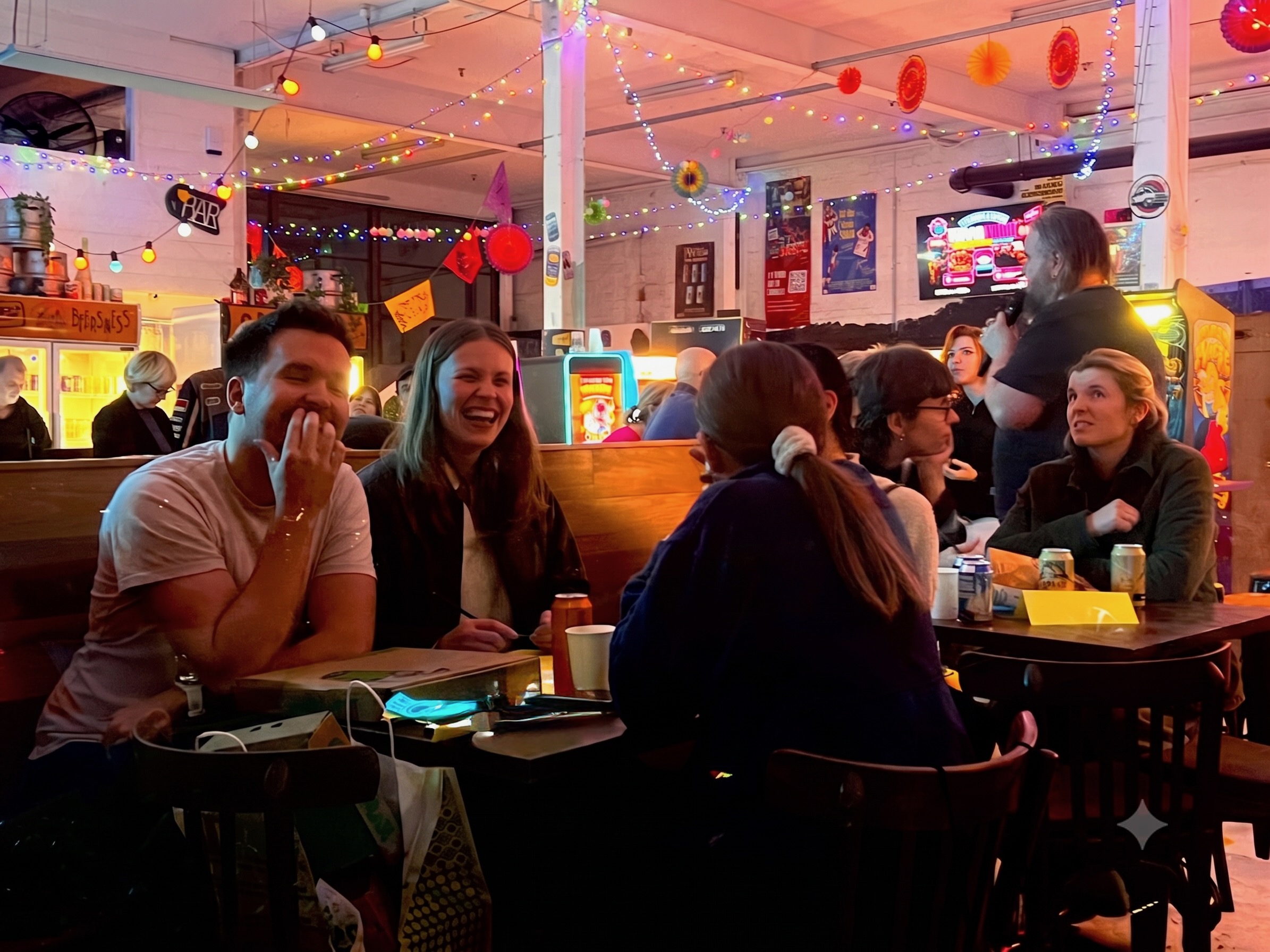 Trivia teams laughing at their table at Wondercade